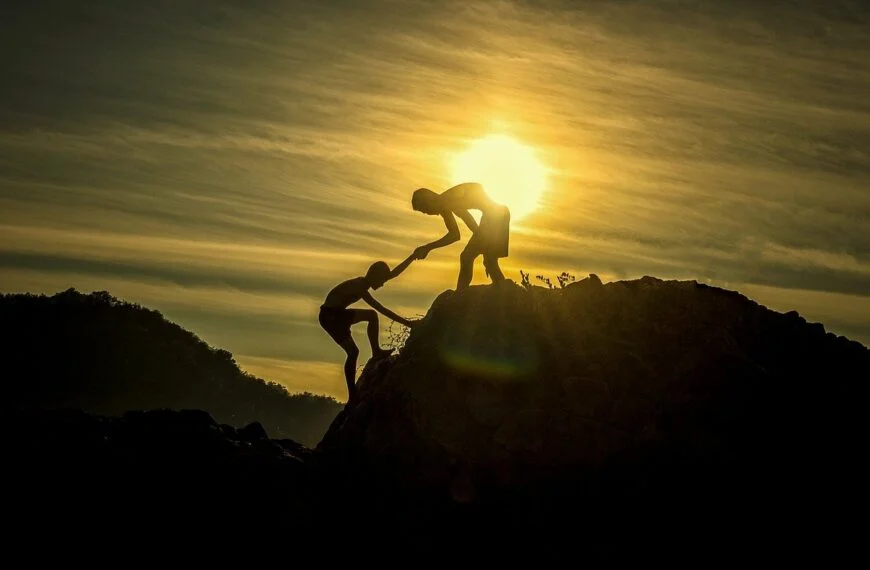 The fear of reaching out 2 Keywords: Sun, Fear Description: Two People Standing On Top Of A Rock With The Sun Behind Them, Overcome By Fear.